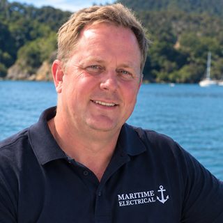 Person wearing a Maritime Electrical polo aboard a boat